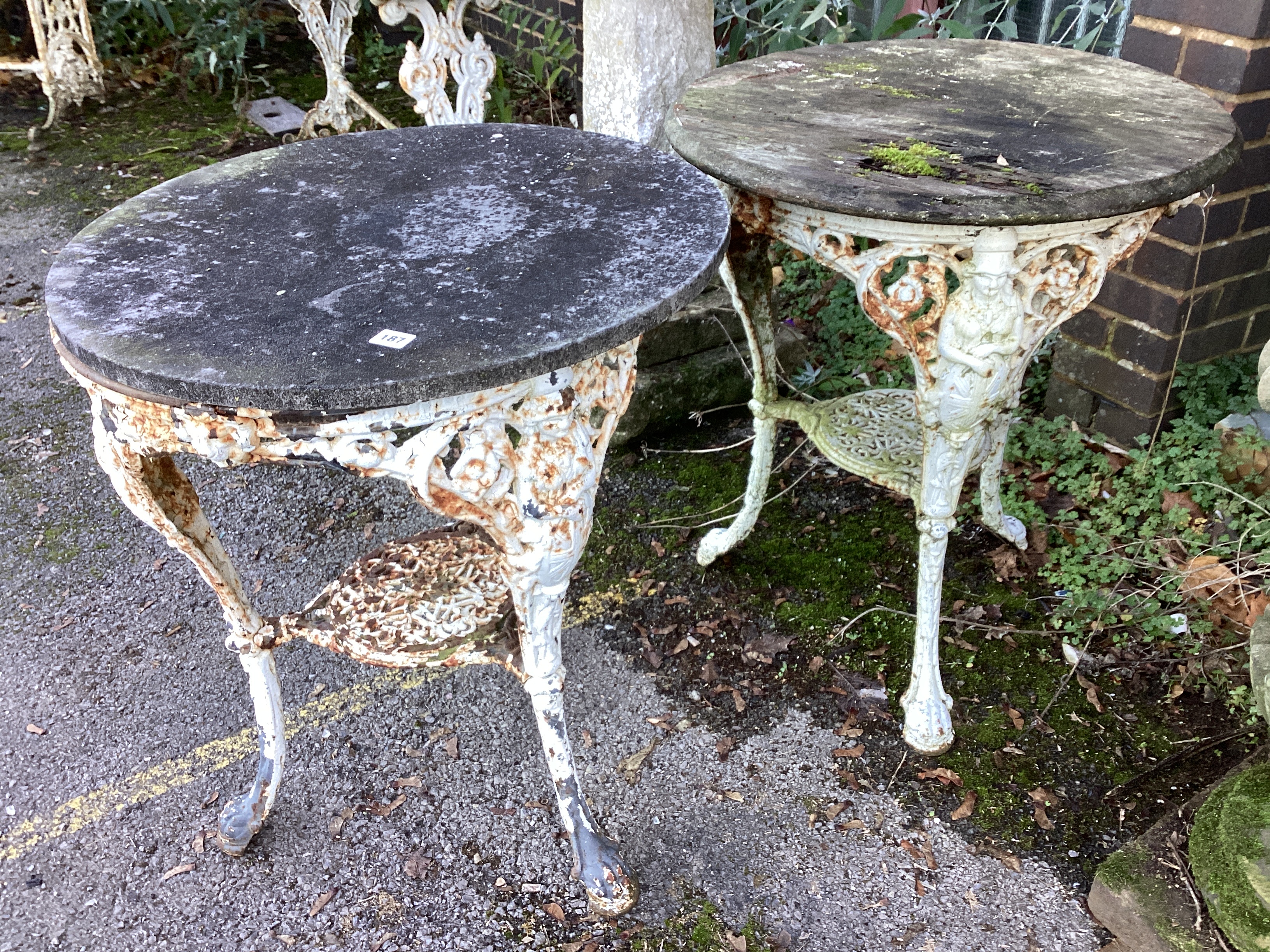 A near pair of Victorian cast iron Britannia pub tables, one with weathered stone top, the other wooden top diameter 63cm, height 75cm